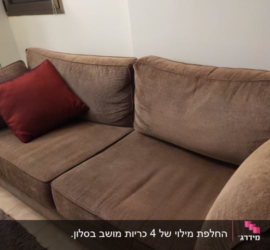 ספה חומה עם כרית אדומה על המושב